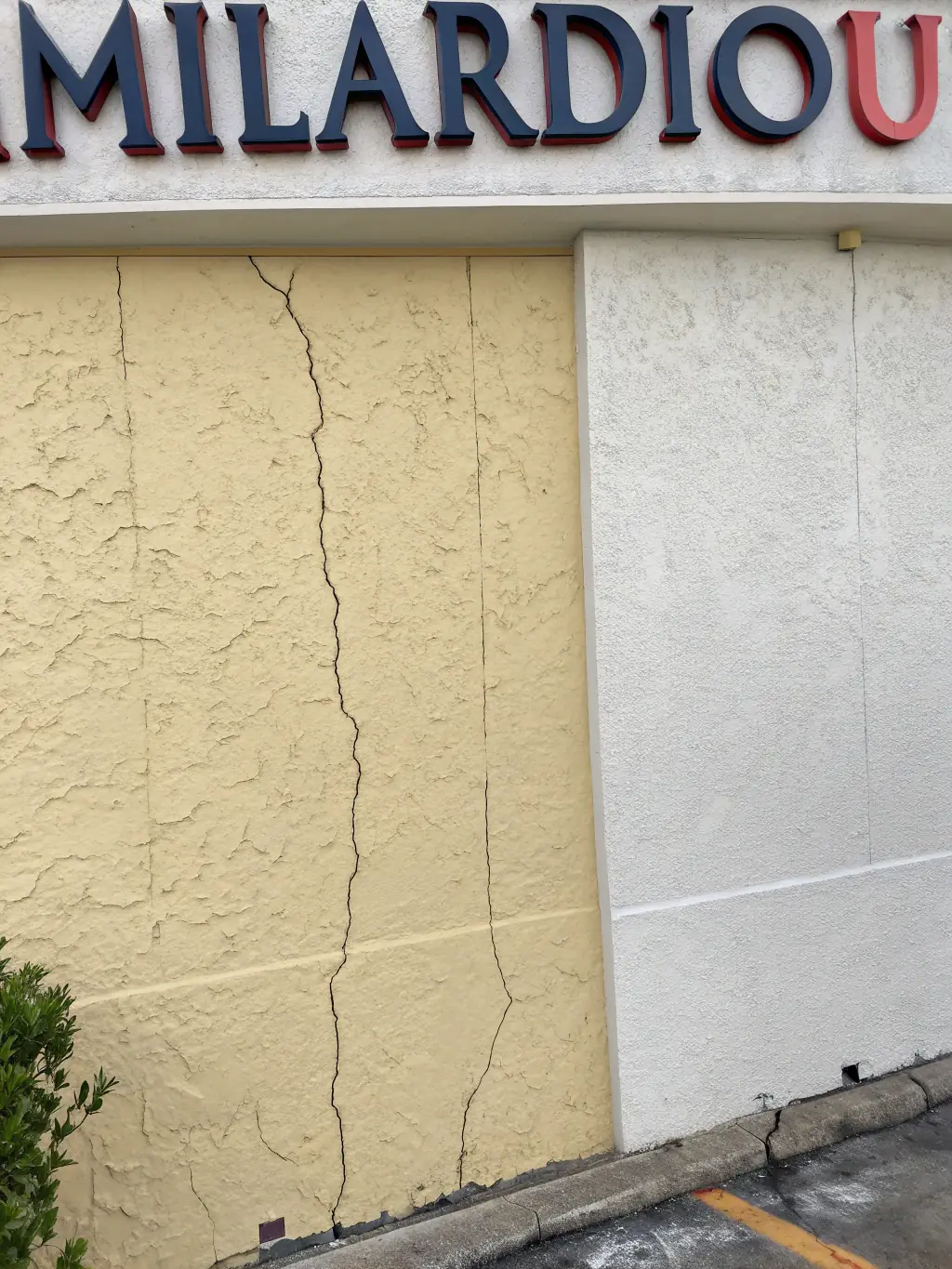 A before-and-after photo showing a damaged wall being restored to its original condition through professional repair work in an Oklahoma office.